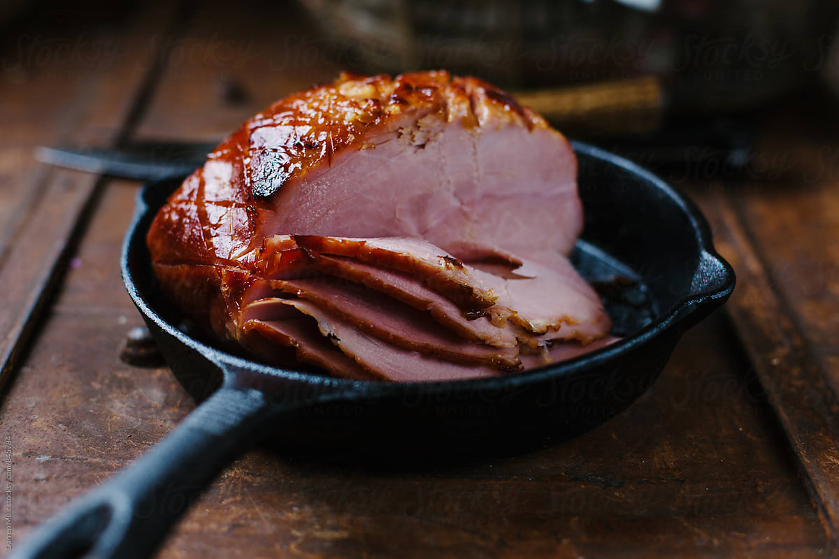 Honey baked ham in a cast iron skillet.