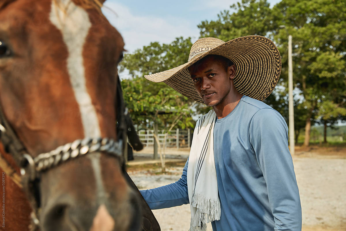 A young cowboy is portrayed with his horse on a Colombian ranch.