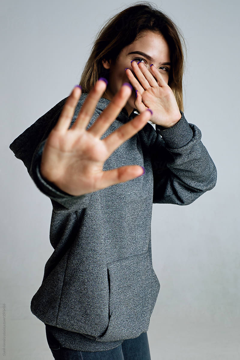 Teen Girl Hiding Face With Palm Hand From Camera By Danil Nevsky