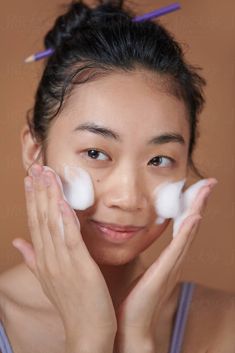 Cute Asian girl enjoy herself with bubble cleansing foam