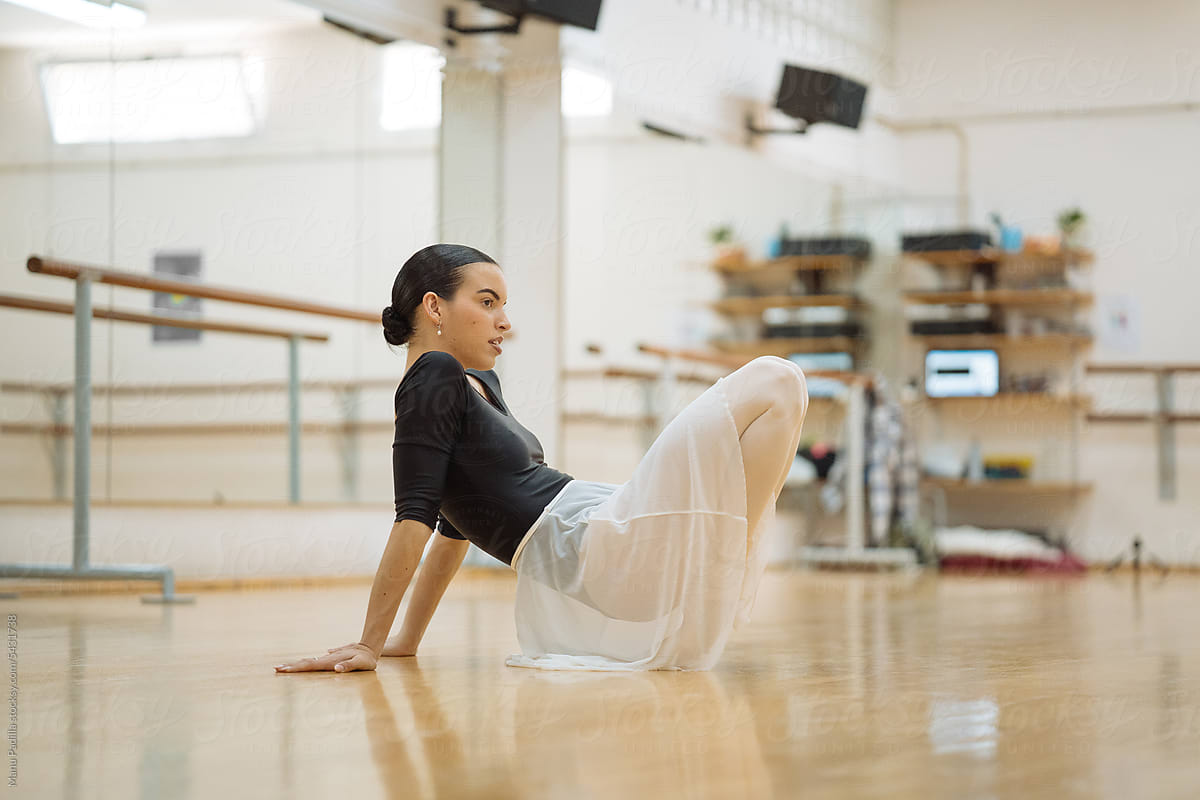 Graceful ballerina dancing in spacious ballet studio