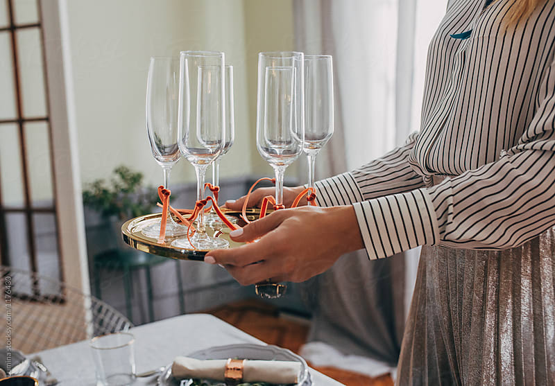 Woman Holding Tray With Wine Glasses For Christmas Dinner