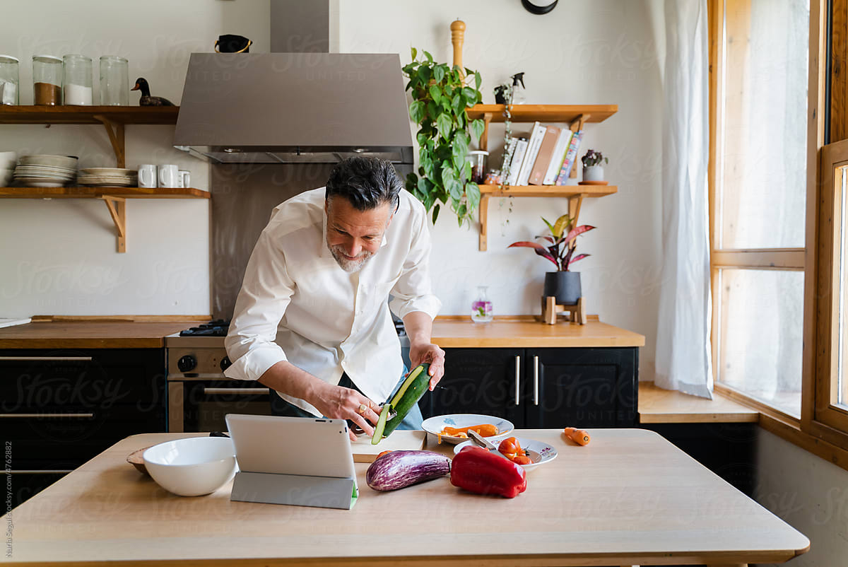 Man Cooking Using Tablet At Kitchen