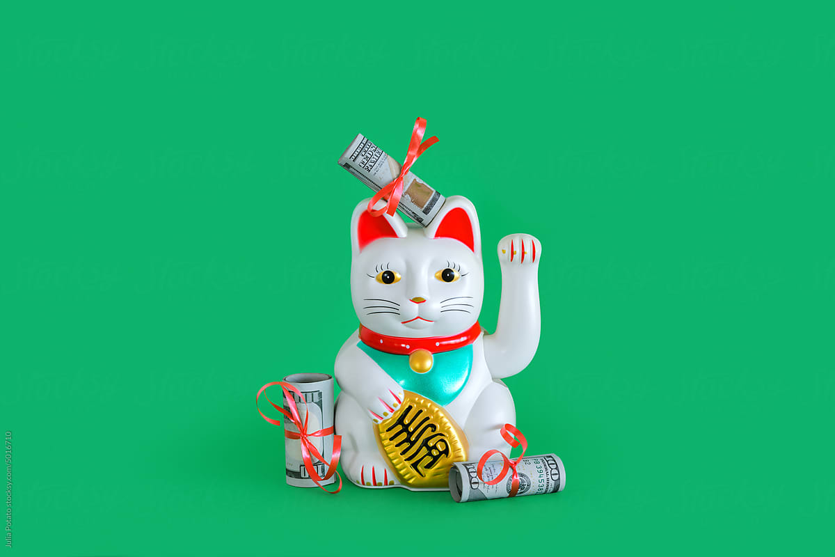 Chinese lucky waving cat with money around it