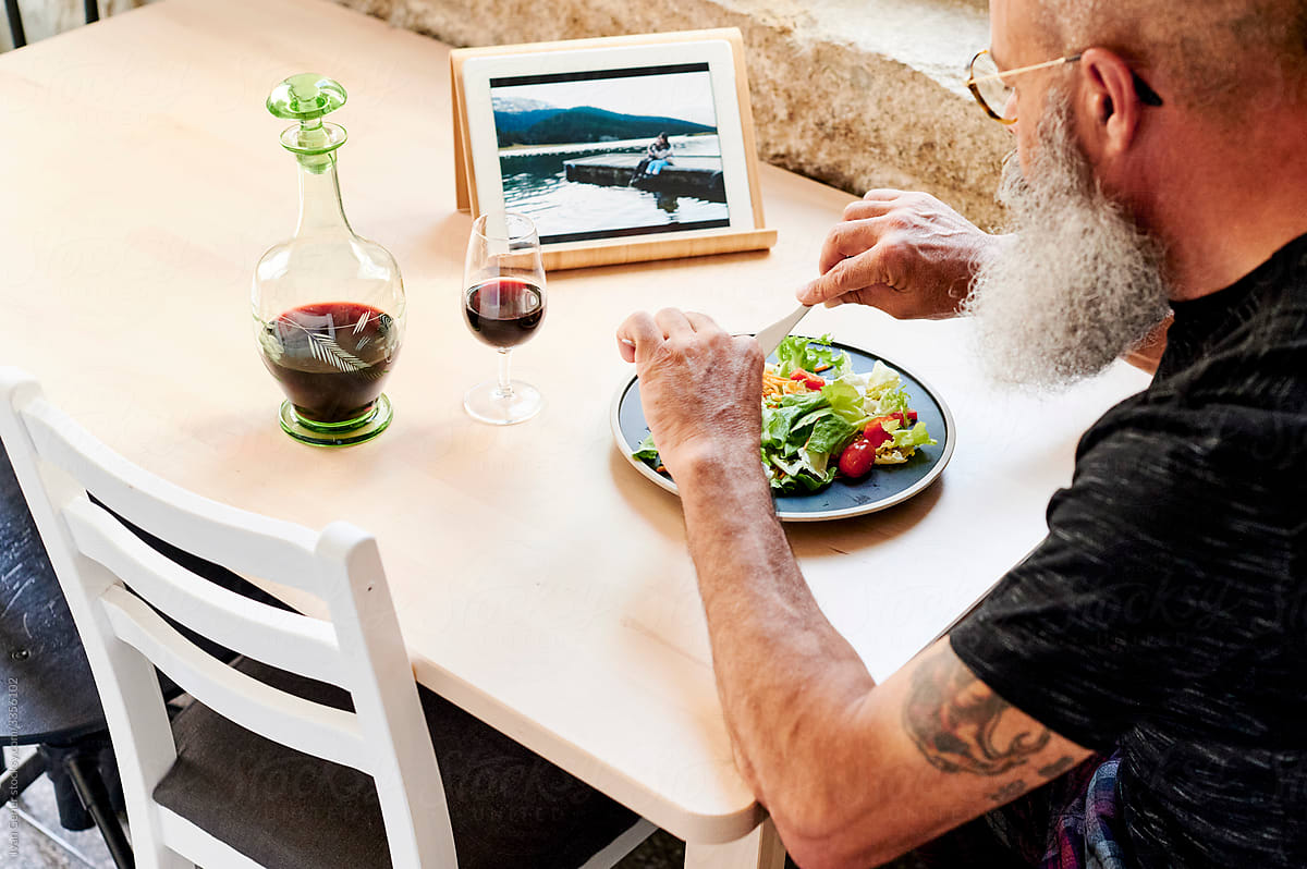 Mature man using a tablet over dinner