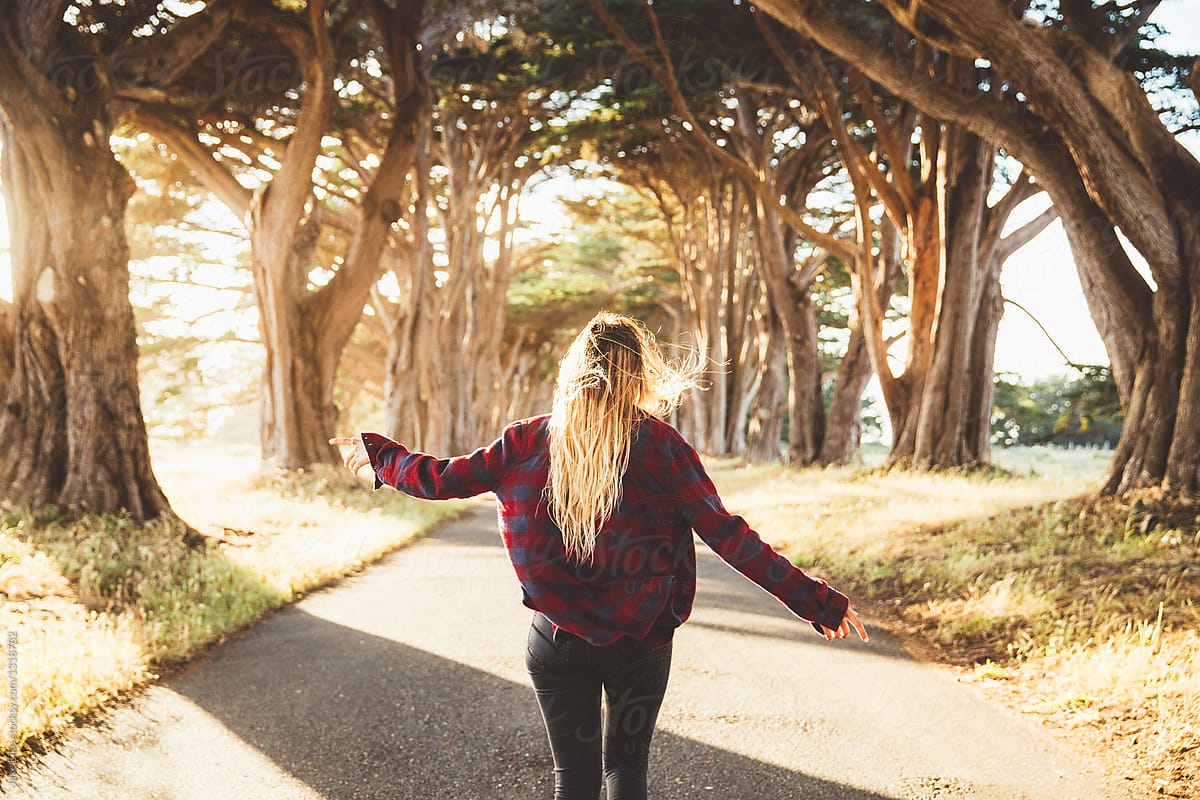 Woman is standing in a tree tunnel in California
