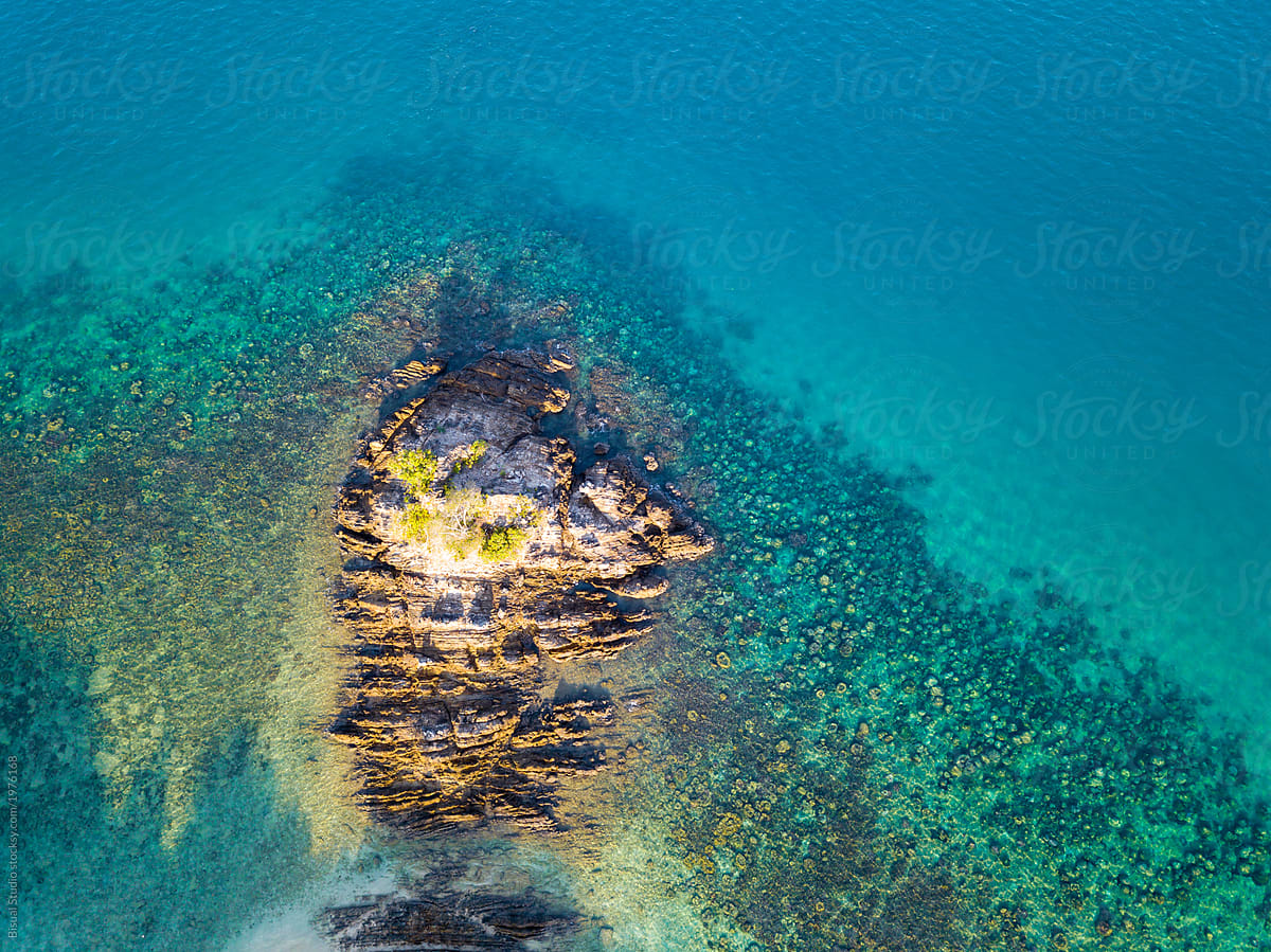 Drone shot of green island in emerald waters in Kapas, Malaysia