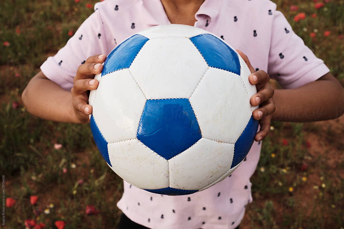 Boy in pink t-shirt holding a soccer ball