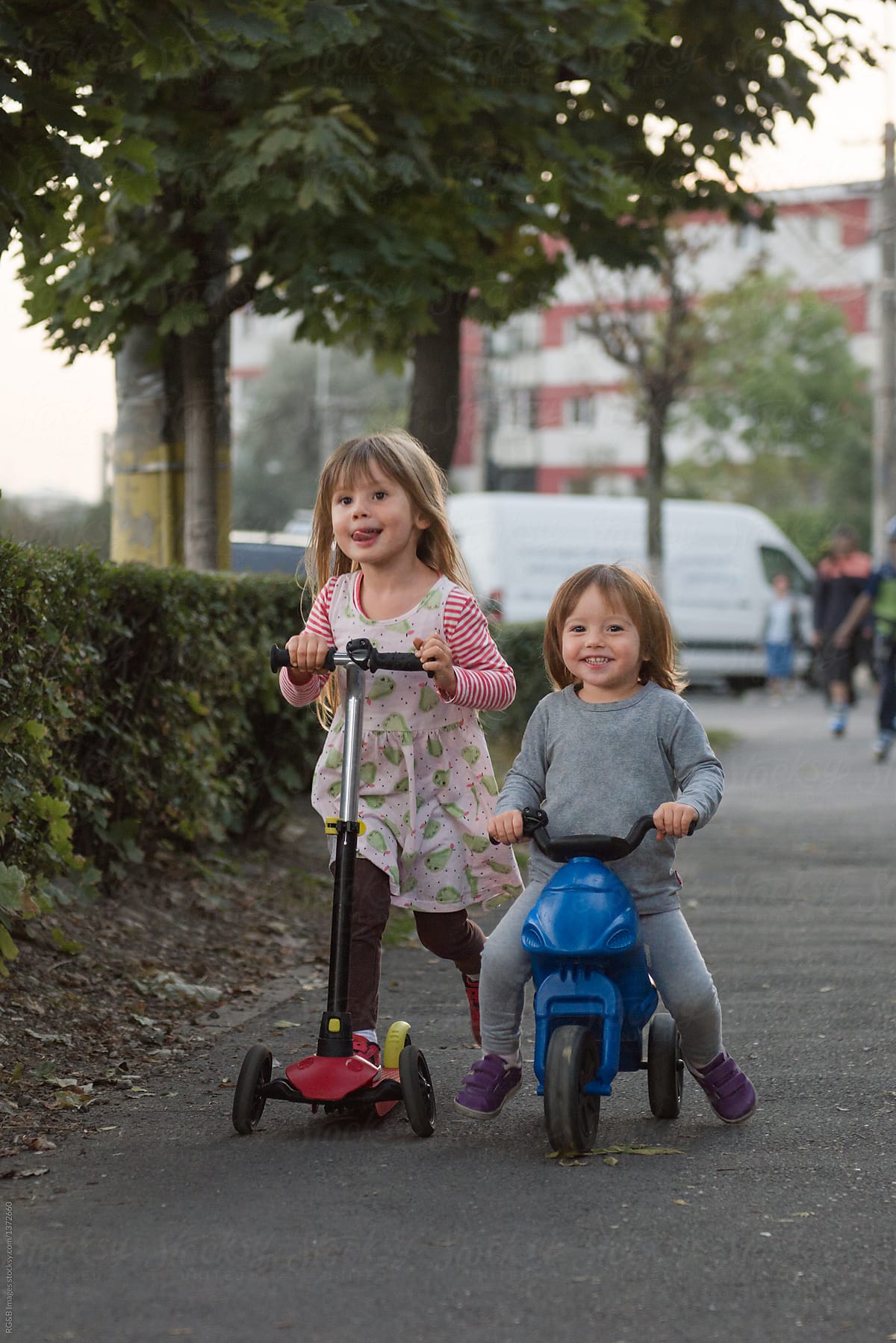 Children riding scooters on the sidewalk