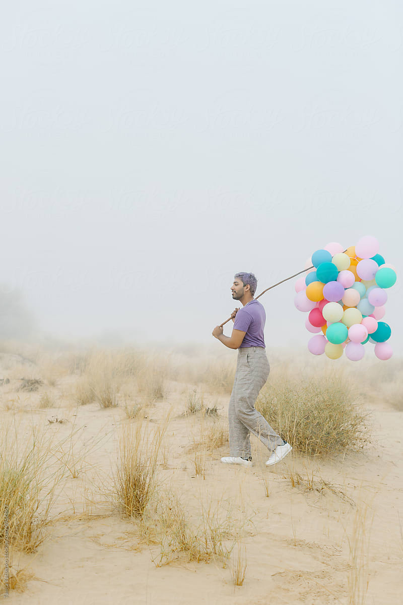 A man with balloons in the mist