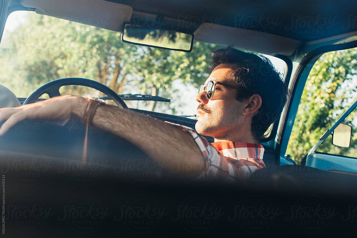 Young Man Chilling in Vintage Car and Watching Summer Sunset