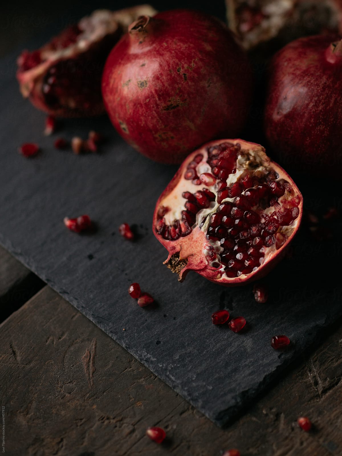 pomegranate and seeds freshly opened on wooden kitchen farm table