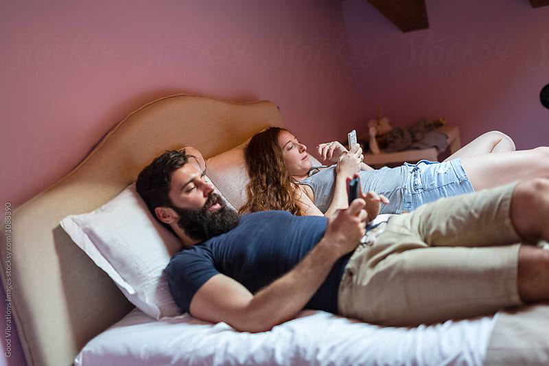Couple in the bedroom holding cellphone