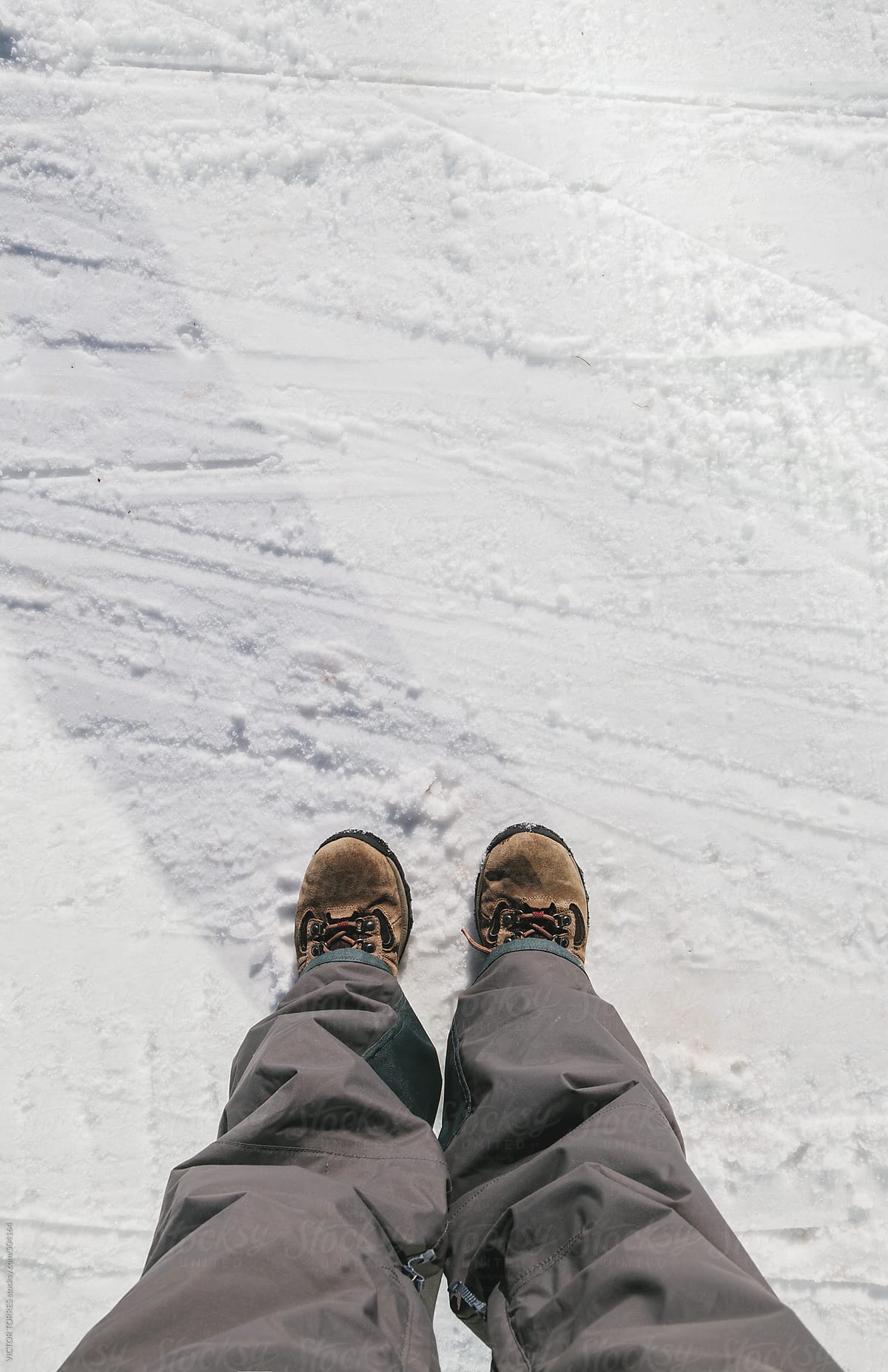 Man Standing on a Snowy Floor with Mountain Boots