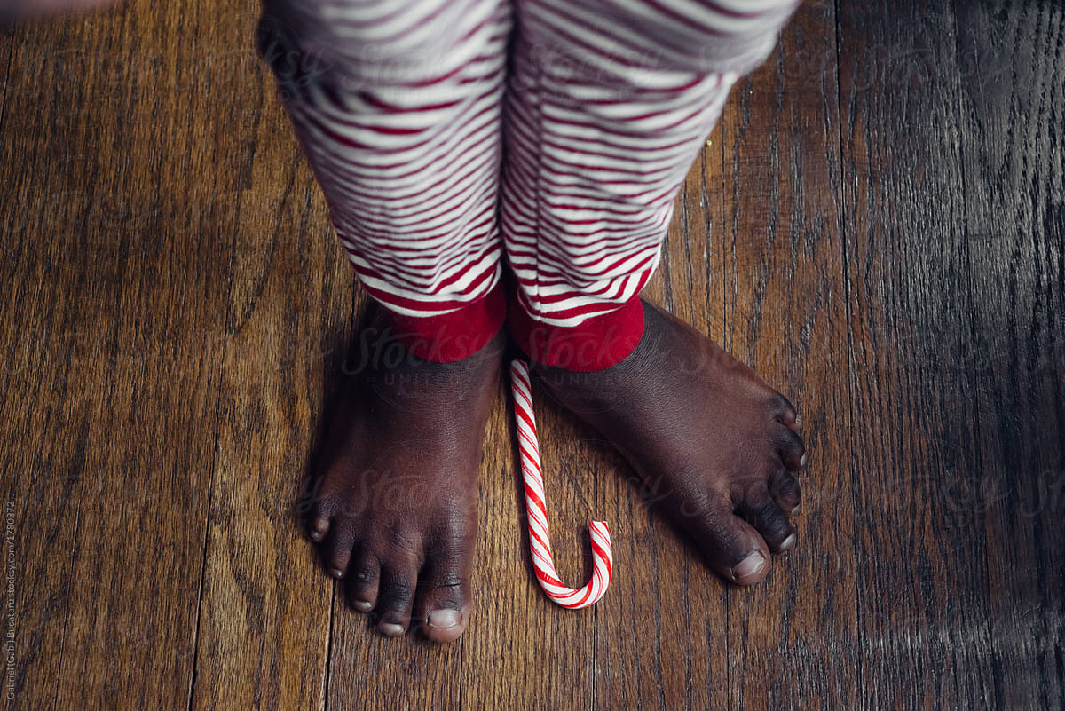 Black girl\'s toes and a candy cane