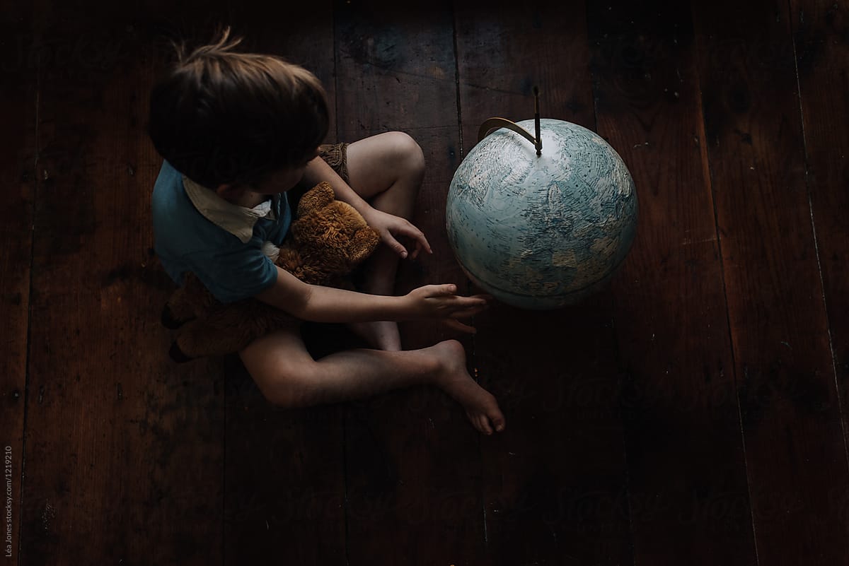 little boy looking at globe