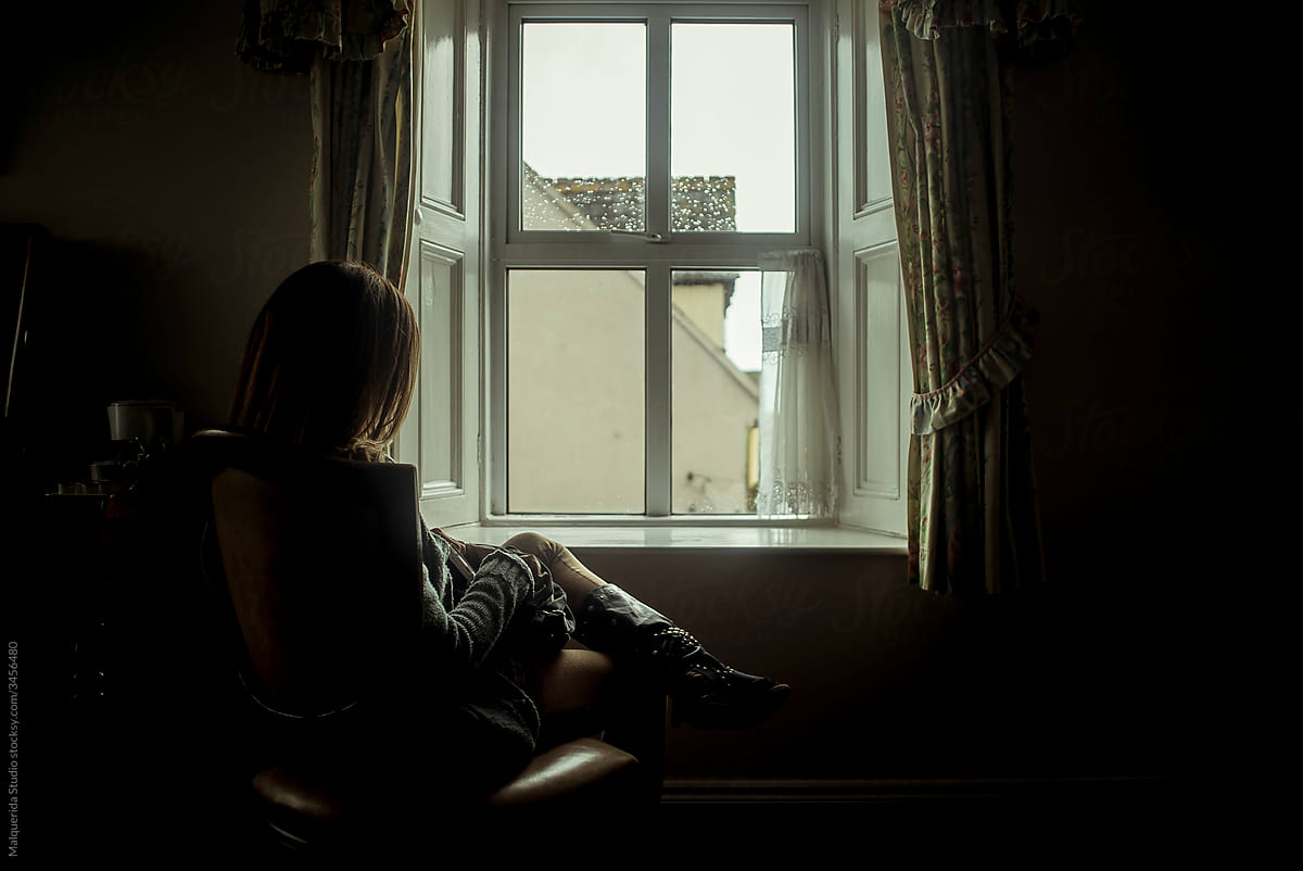 Young woman sitting in front of a window