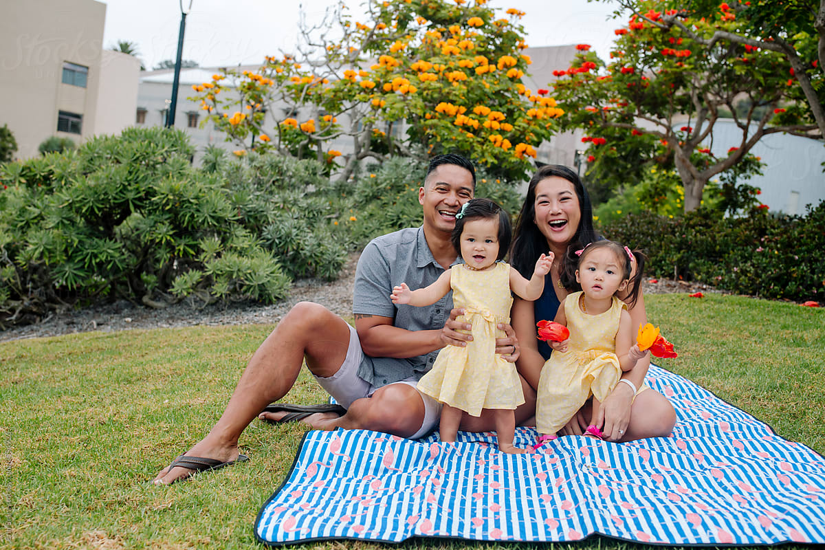 Happy young asian family outdoors on blanket