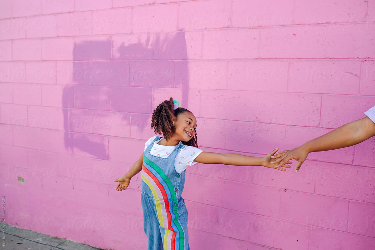 Dancing girl in front of pink wall