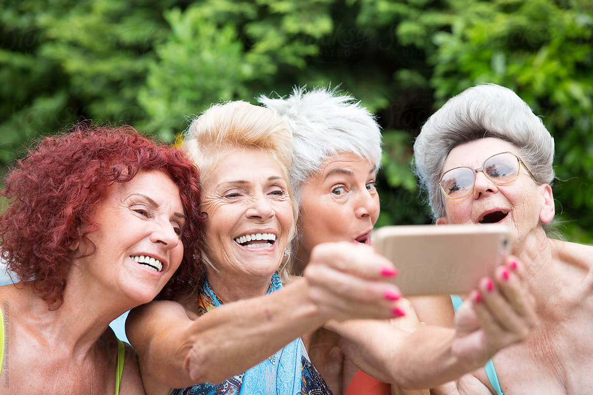 Four mature women friends taking a selfie outdoors