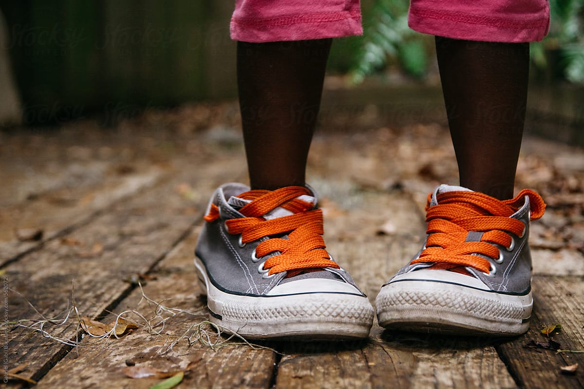 Feet of a black child in adult size tennis shoes