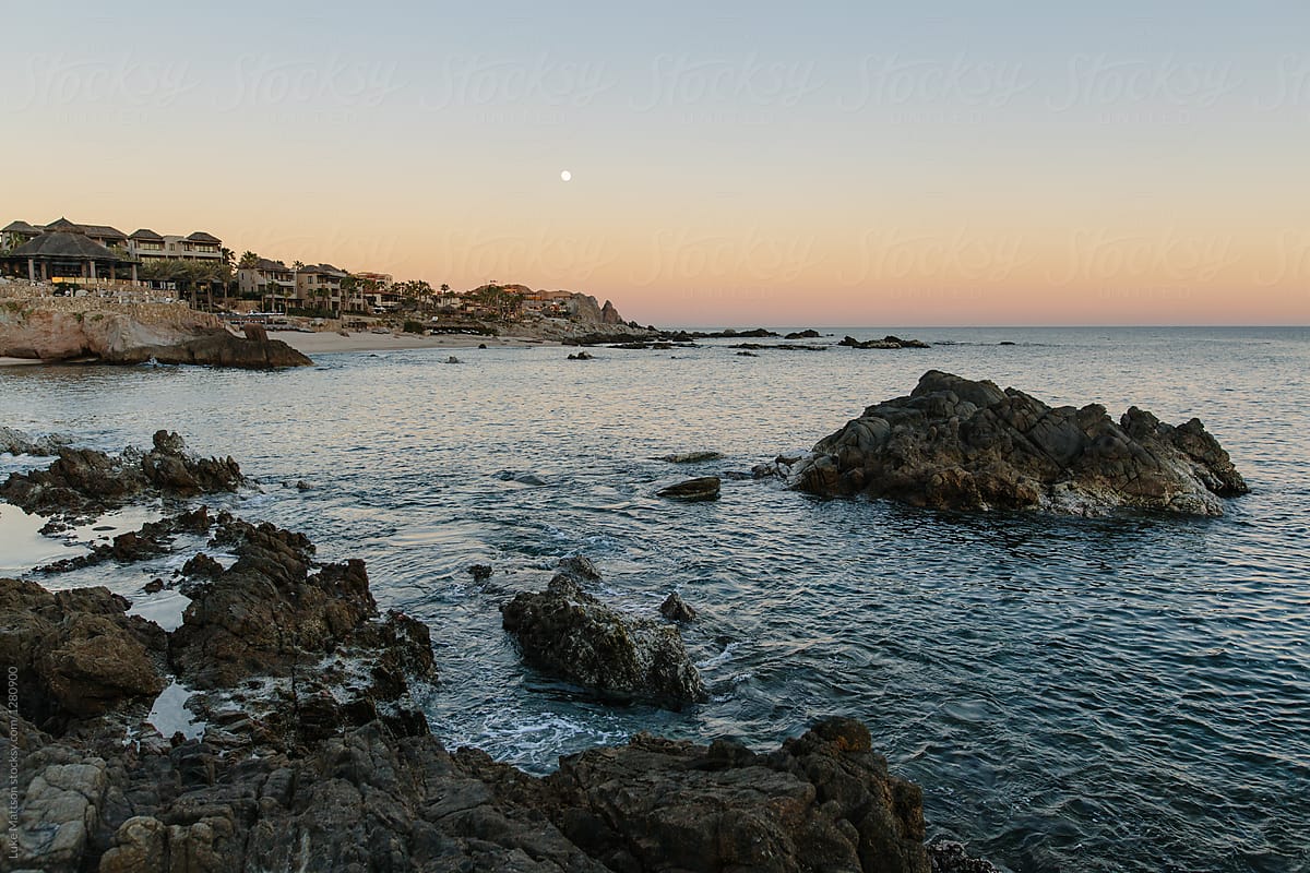 Sunset And Early Moon Over Rocky Ocean Coast