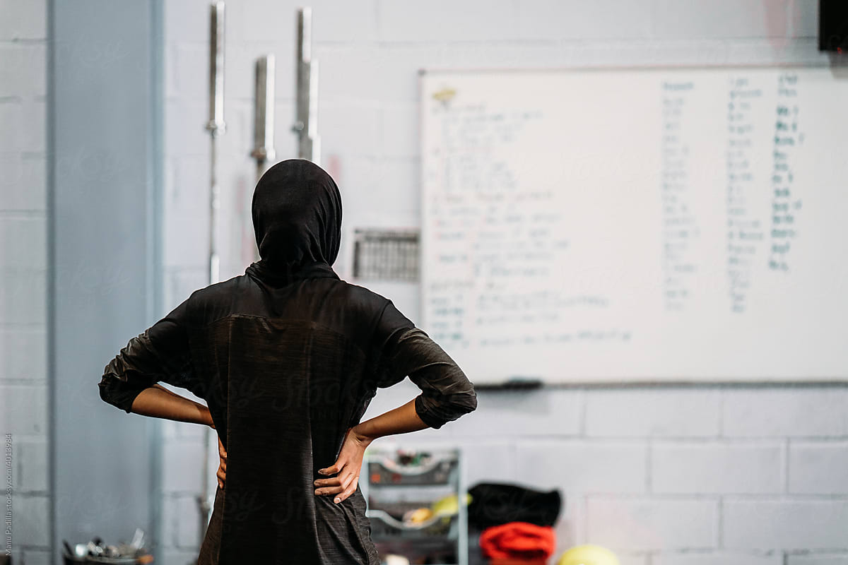 Unrecognizable Muslim sportswoman standing in gym