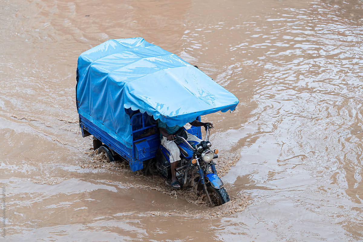 motorcycle passing through flooded road in africa