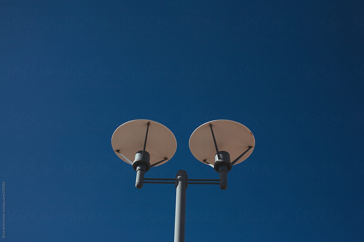 Two-pronged street light in the middle of blue sky