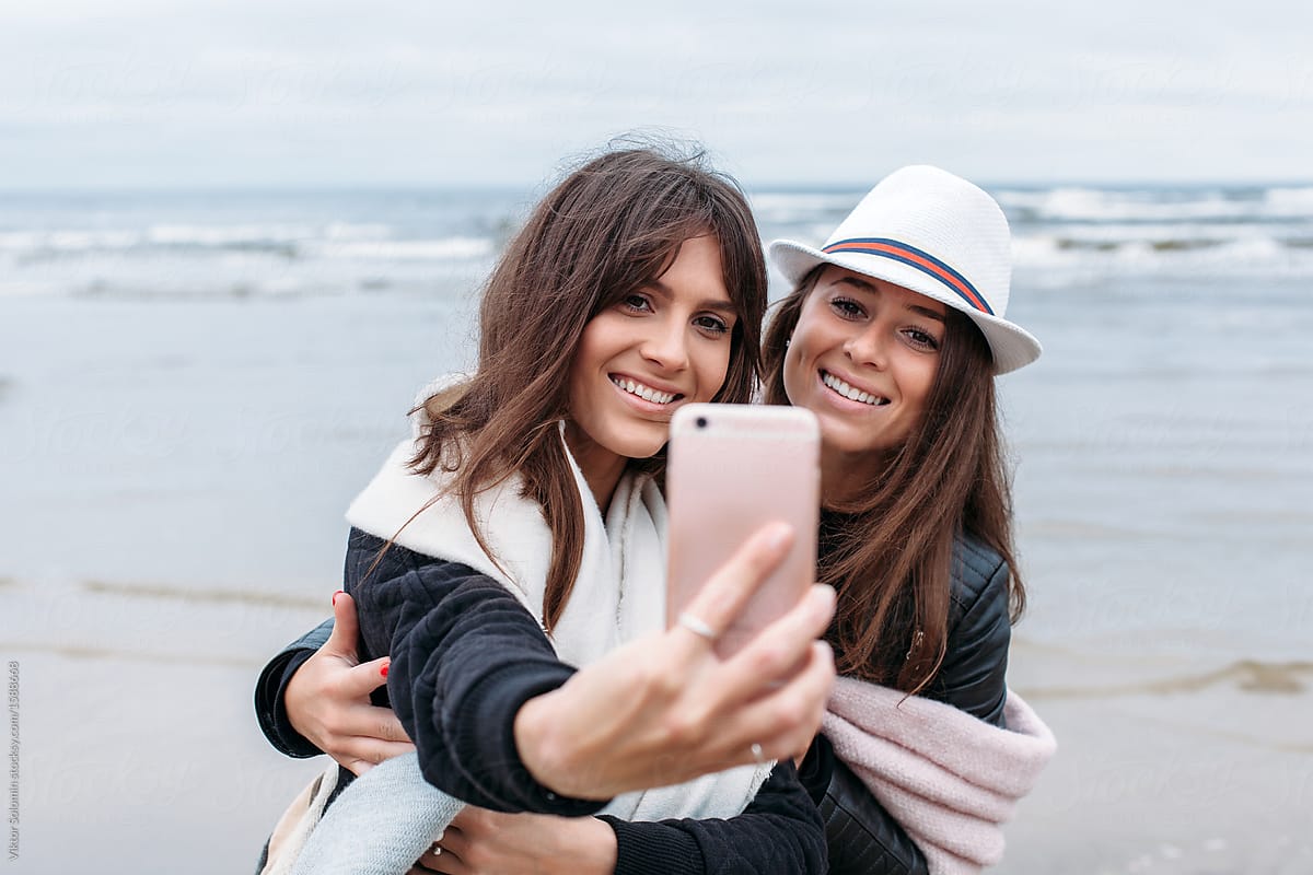 Two happy women taking photos outdoor