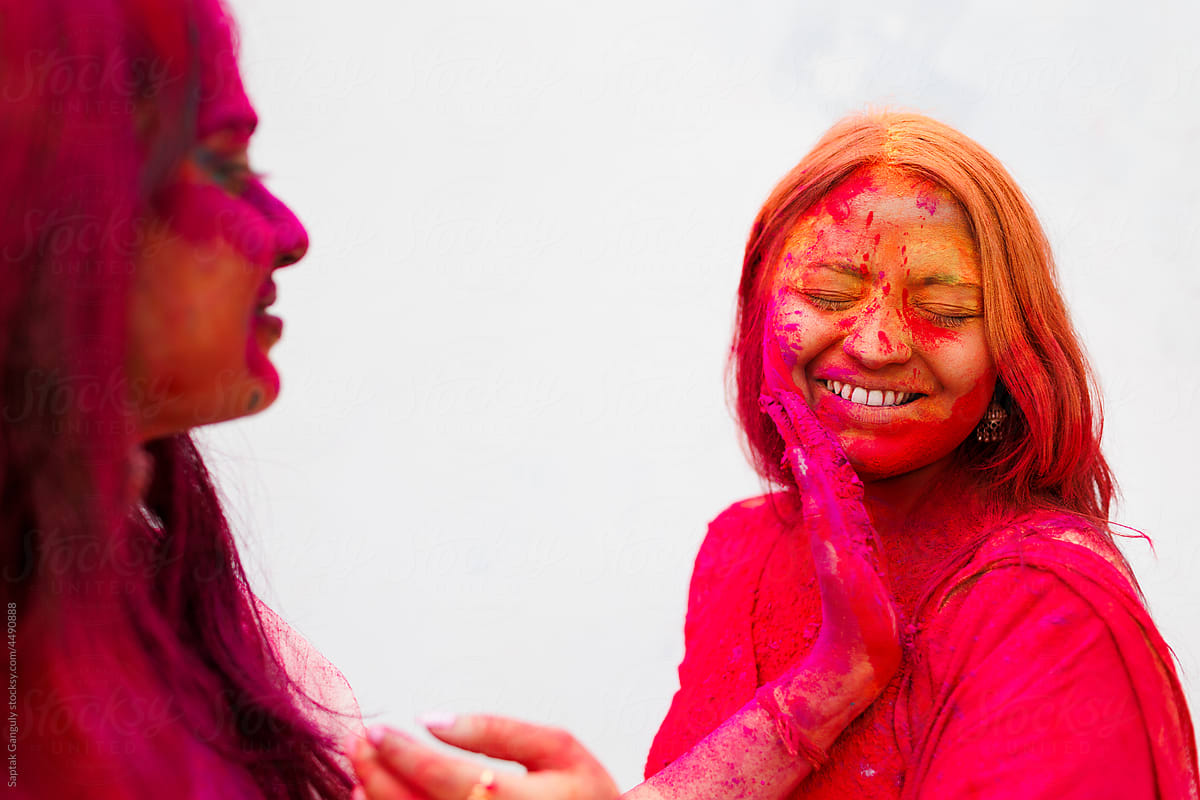 Young women enjoying holi together with color powder