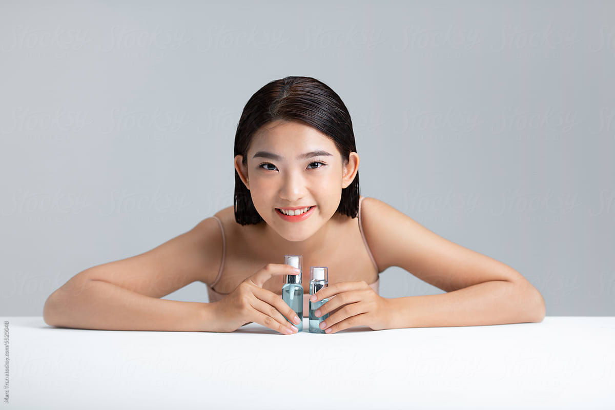 Portrait of attractive woman holding in hand cosmetic facial cosmetic
