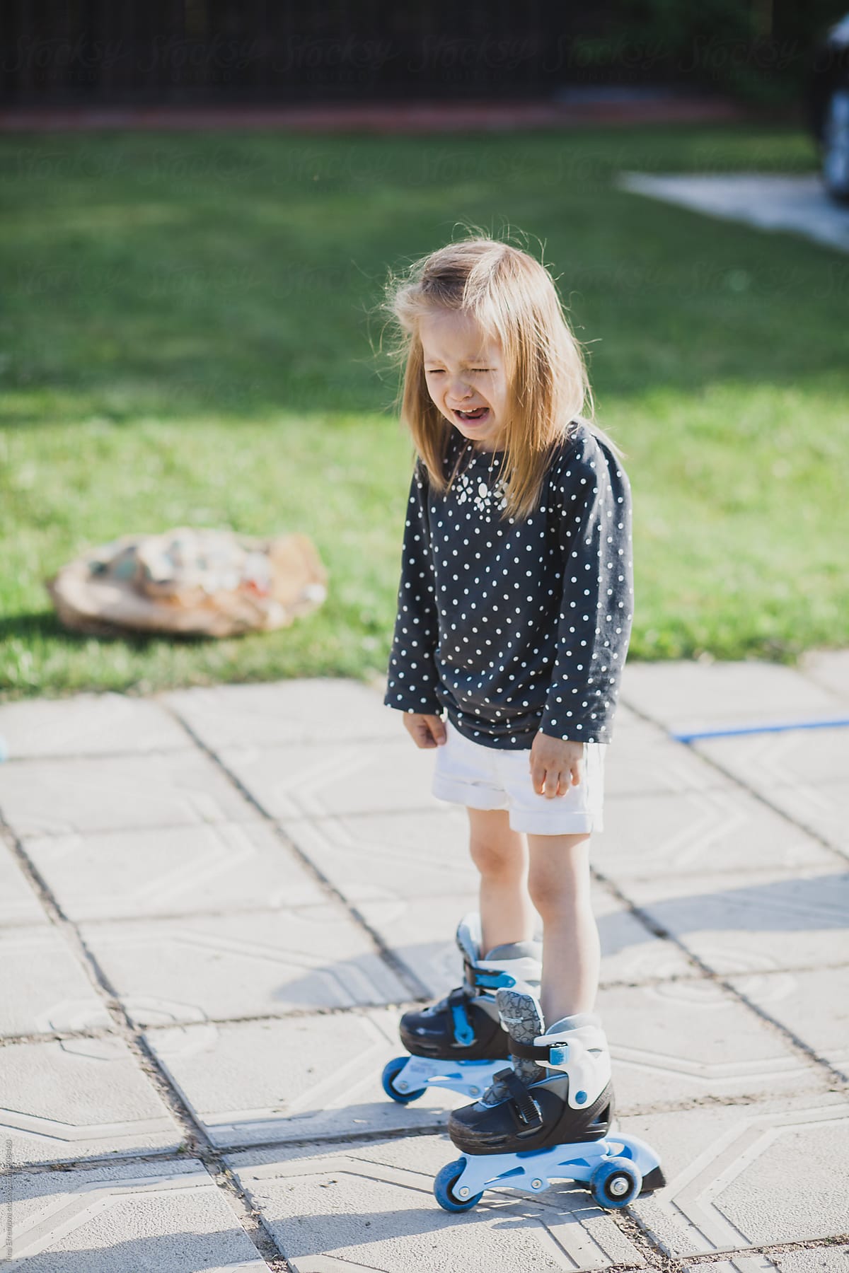 Crying girl standing on roller skates