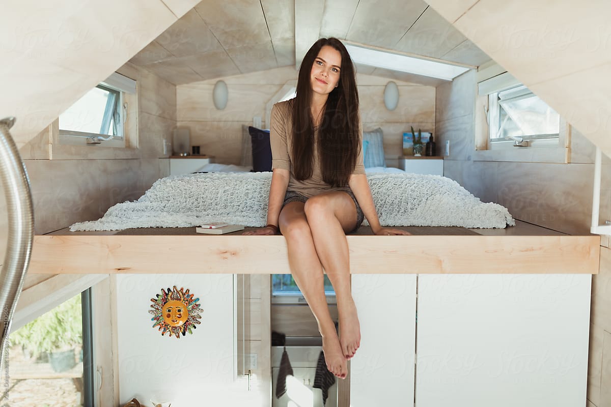 Young woman in the loft of a tiny home.