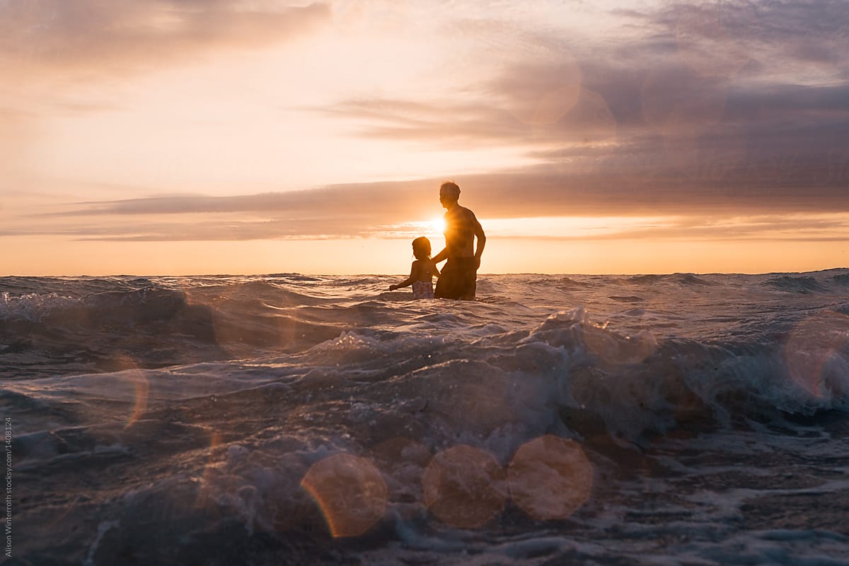 A Man Leads His Granddaughter Into The Water