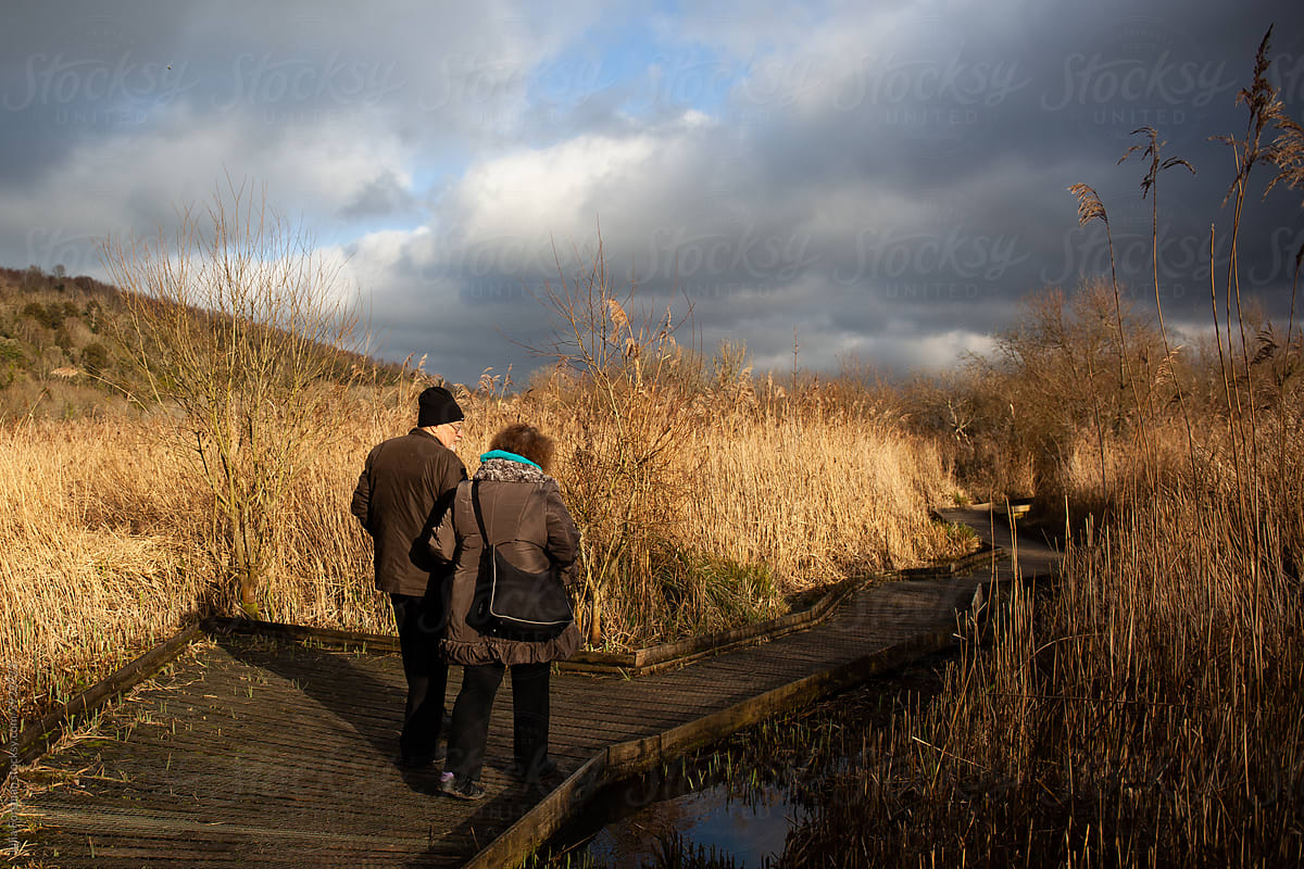 Senior couple walk in beautiful landscape.