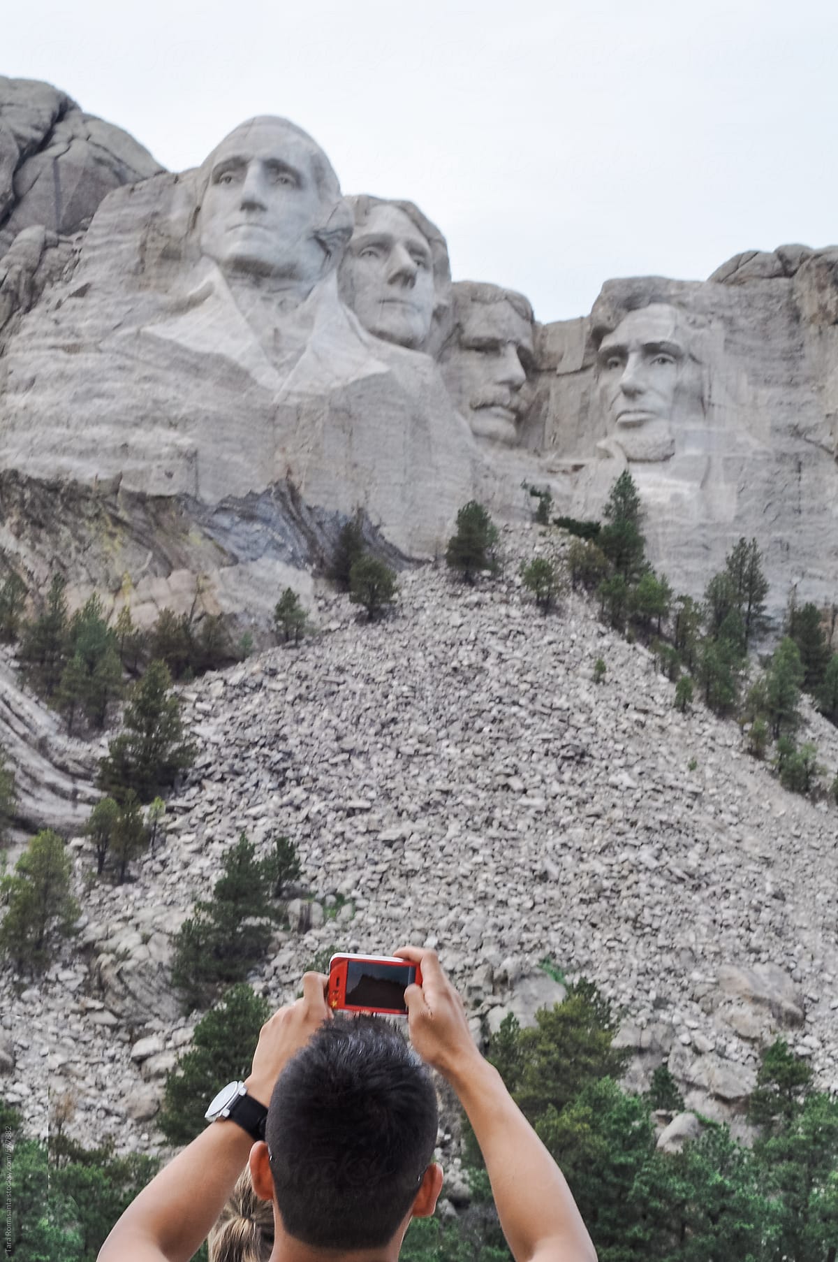 tourist takes photo of Mount Rushmore with his mobile phone