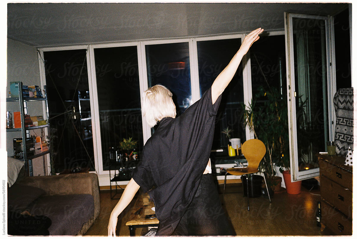 Blond short hair woman wearing black dancing inside living room