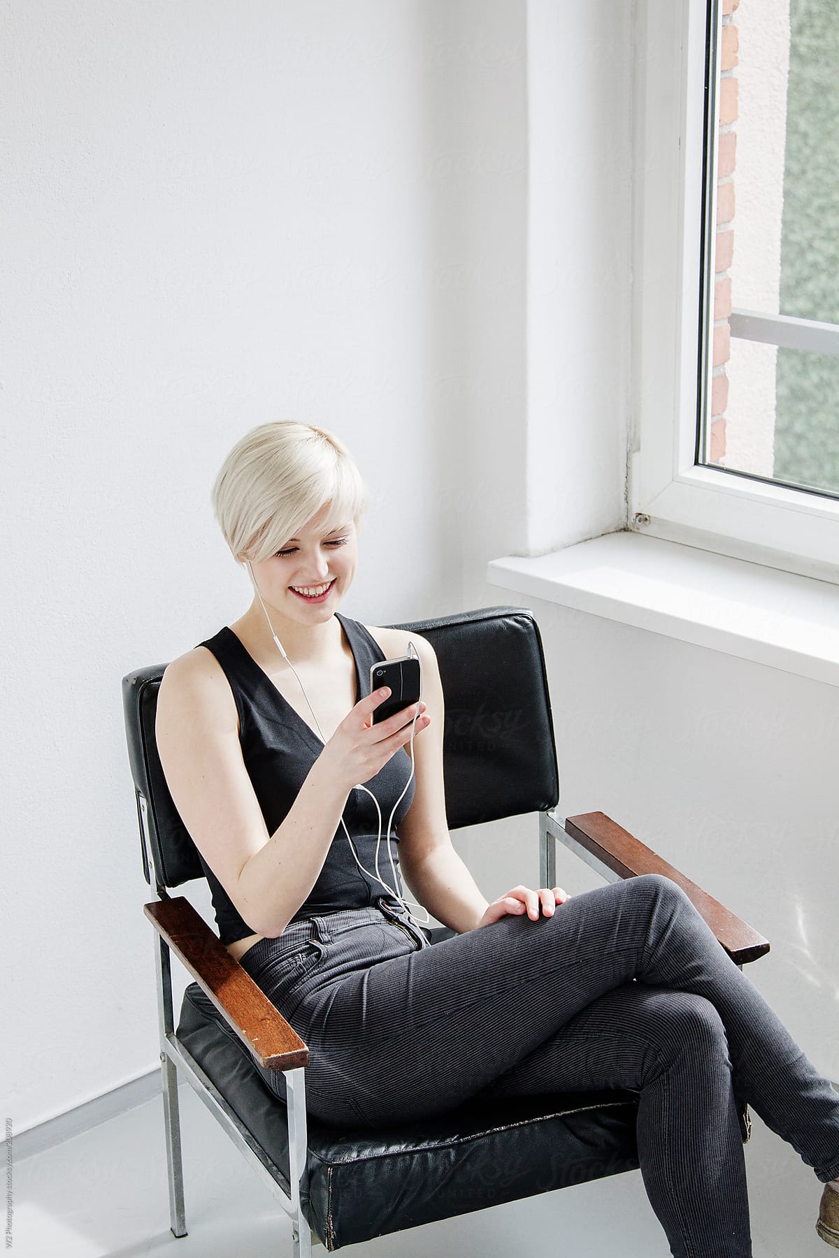 Smiling young woman sitting and talking on smart phone.