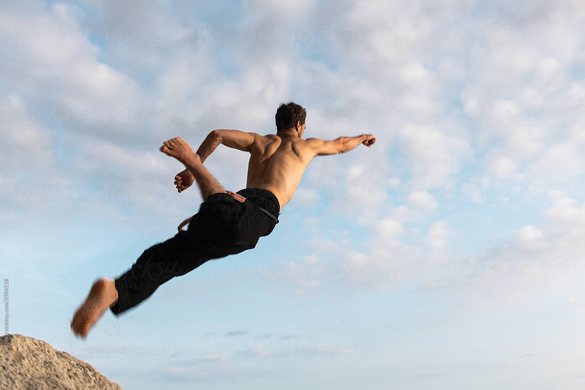 Man Jumping Up To The Sky By Stocksy Contributor Alexander Grabchilev Stocksy
