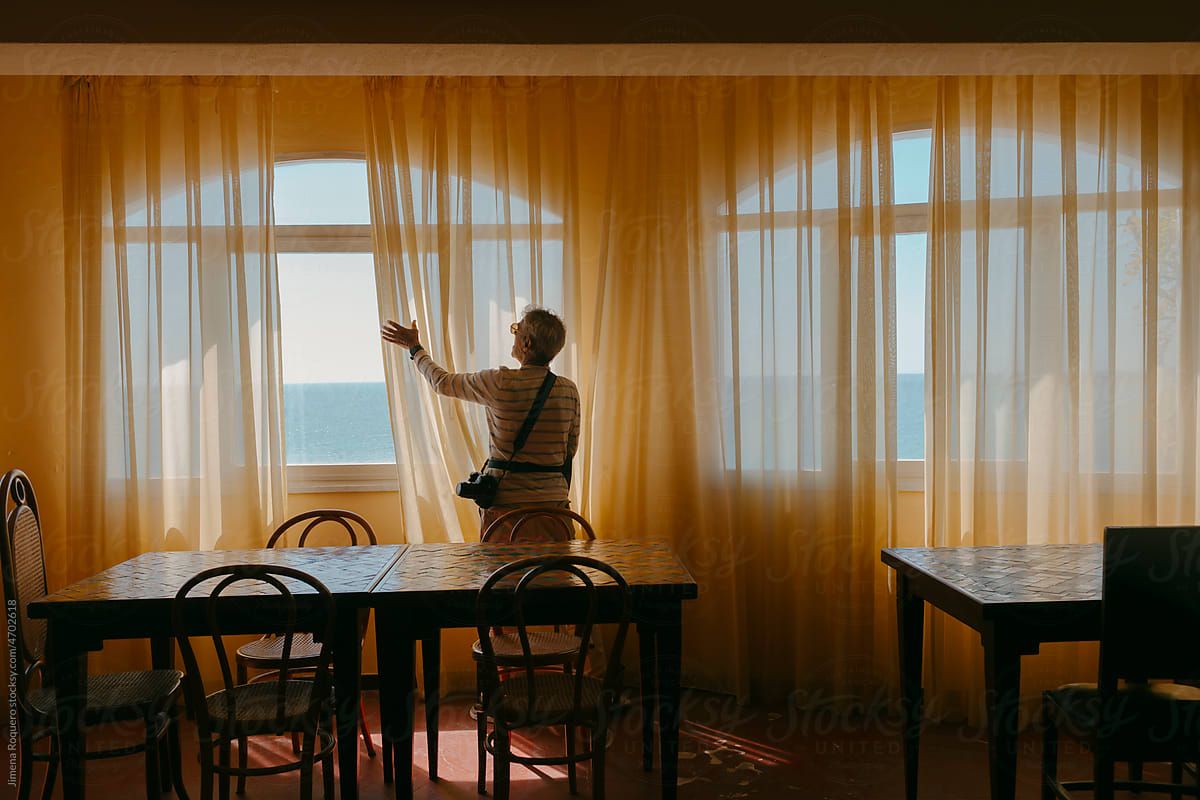 Tourist in hotel restaurant enjoying views of the sea