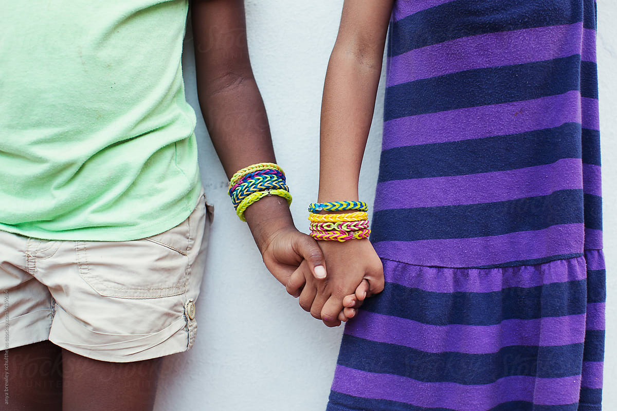 Two children of different races holding hands