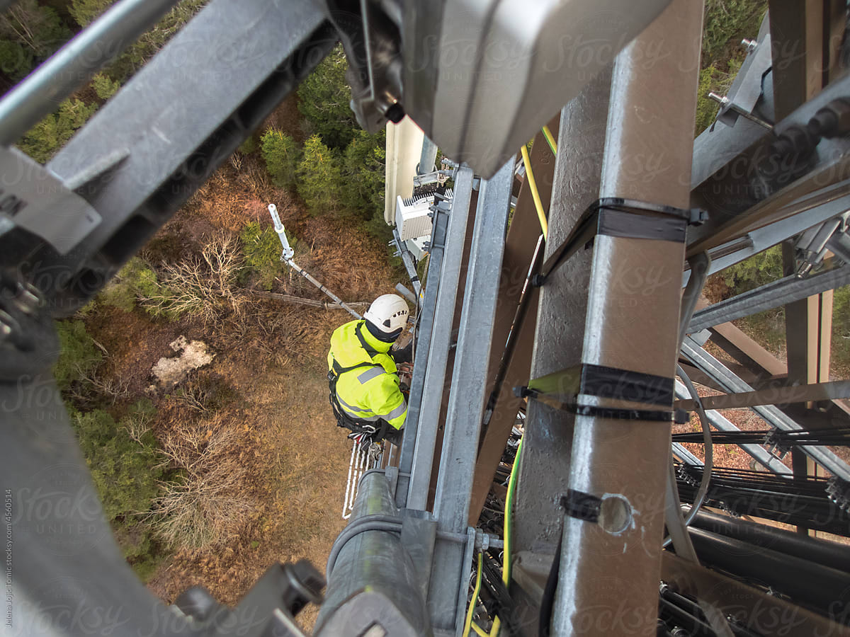 5G fiber optic technician on a telecommunication tower, hights working