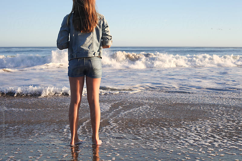 Girl Standing In The Surf Looking Out At The Water By Carolyn Lagattuta