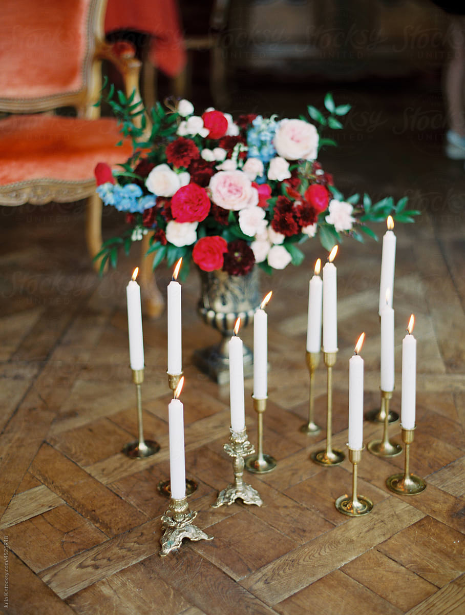 Burning Candles And Flowers On Wooden Floor