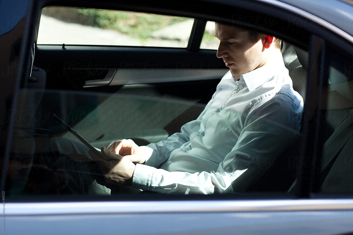 Businessman sitting in the backseat of the car