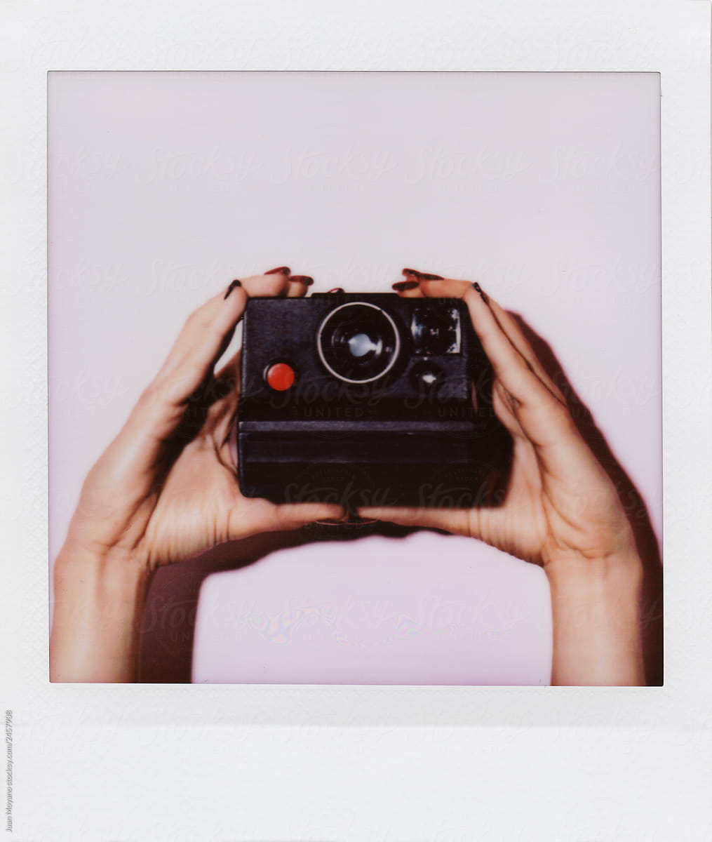 woman taking a picture with an instant camera