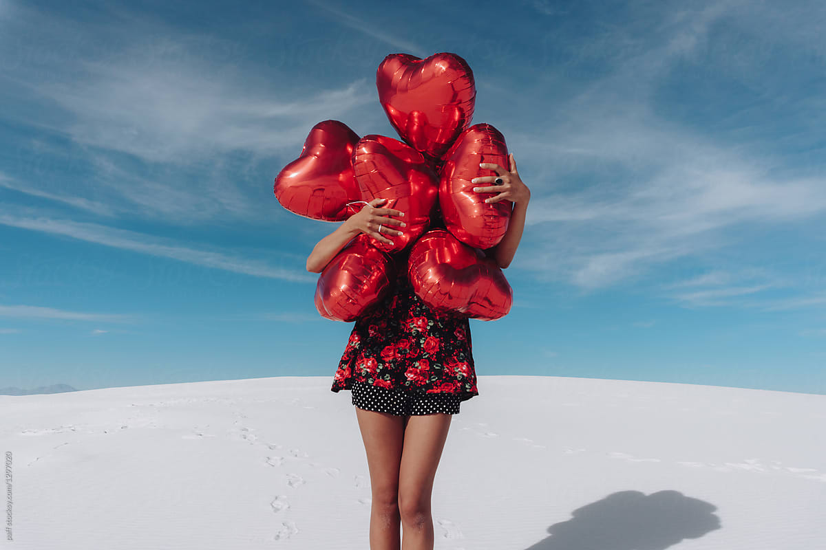 Young woman hugging heart balloons on Valentine\'s Day