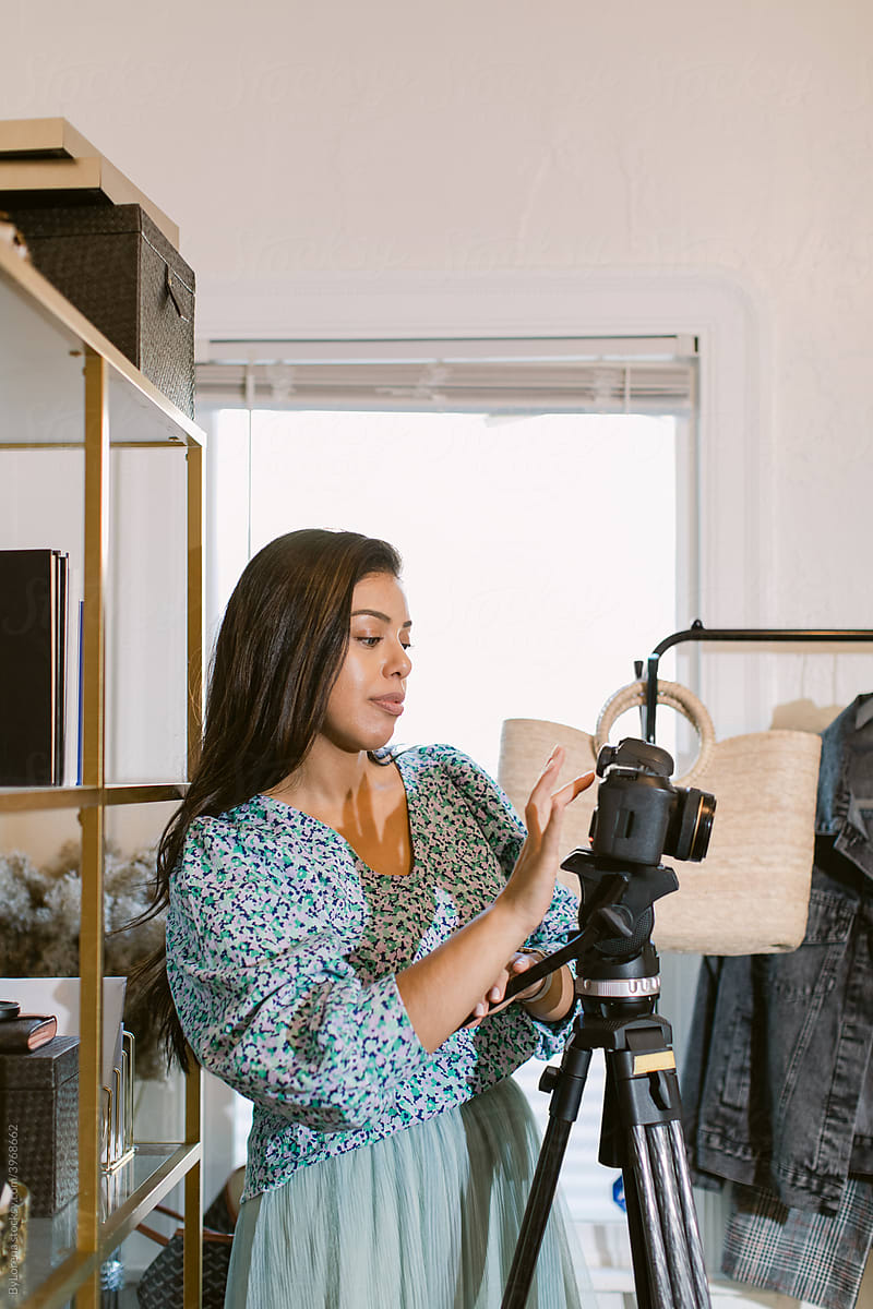 Hispanic woman preparing camera for shooting video for blog