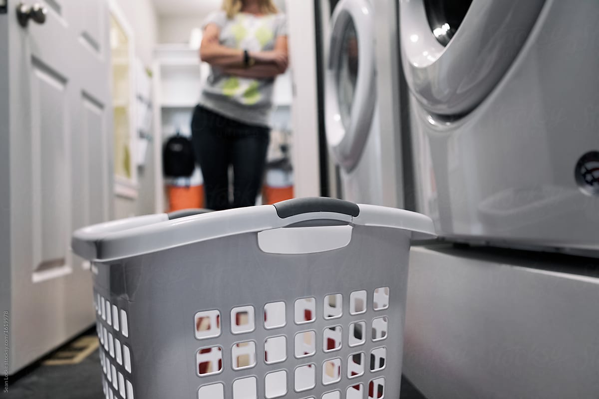 Home: Focus On Laundry Basket As Woman Waits In Background